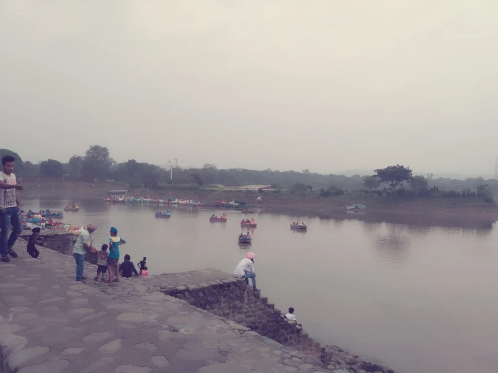 Urban lake with a stone embankment and visitors